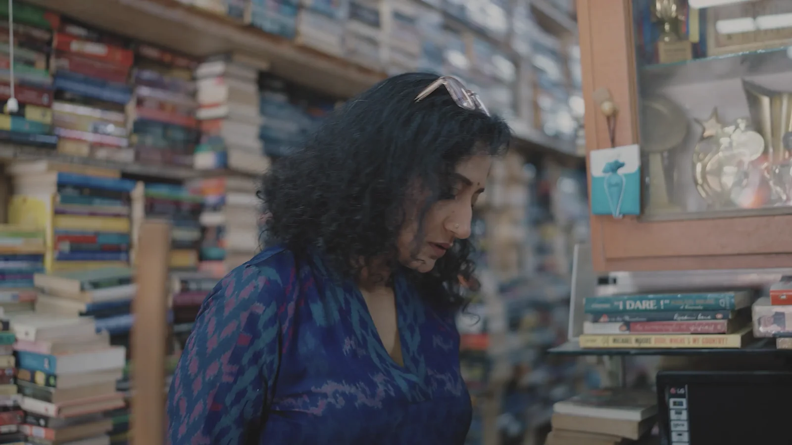 Mugdha Raj looks down among the shelves of her bookshop