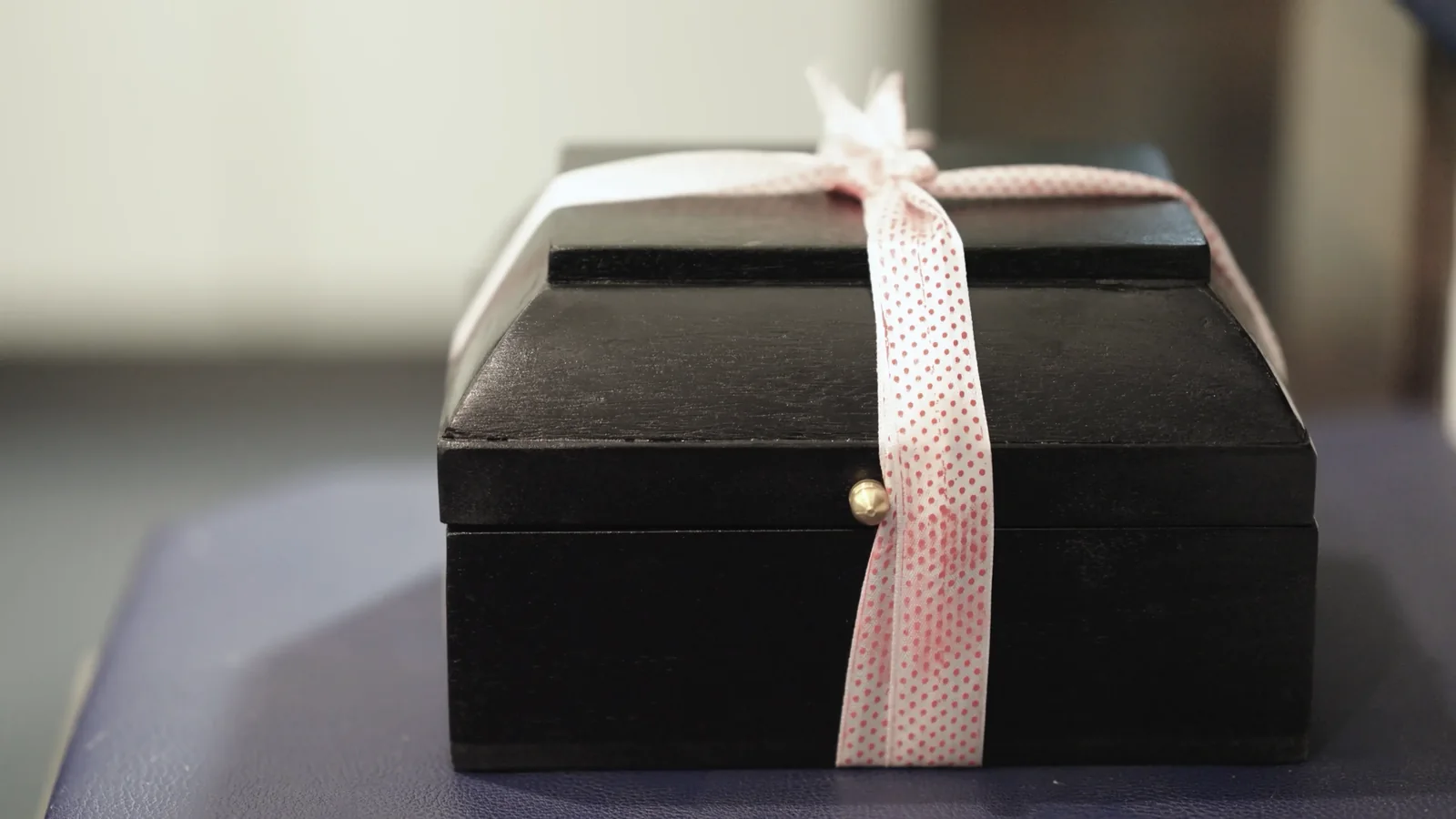 A black box tied with a polka-dot ribbon