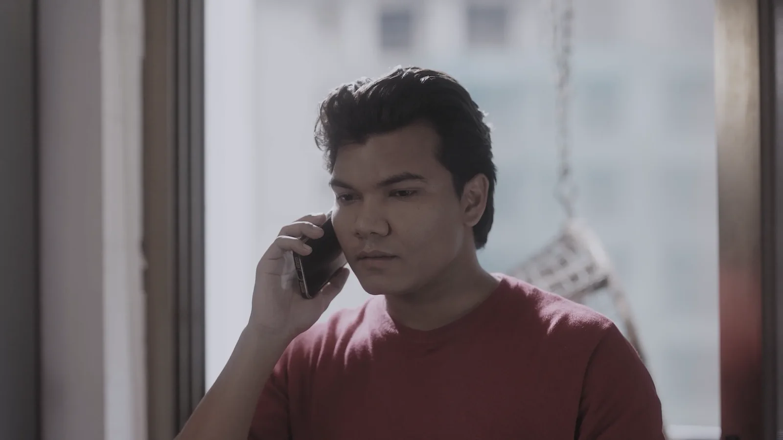 Iswar Mohan on a phone call by a window